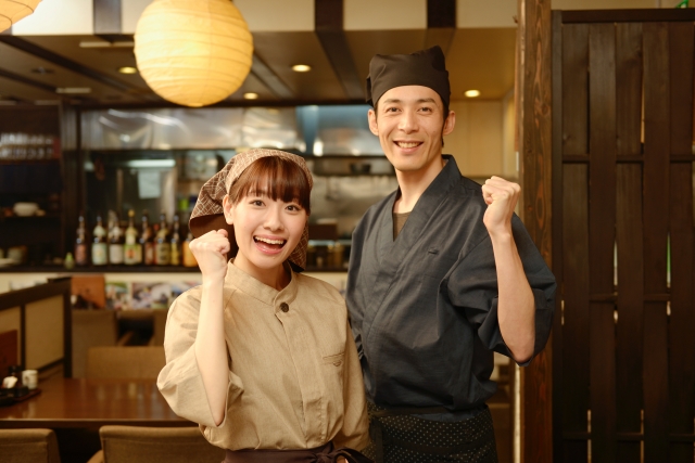 飲食店店員の男女のガッツポーズ